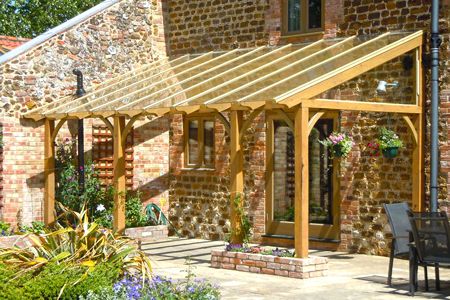 A timber pergola with a glazed roof built as a lean-to on a barn conversion, with small raised brick planters Brick Planter, Timber Pergola, Pergola Diy, Outdoor Sitting Area, Building A Pergola, Pergola Design, Pergola Canopy, Wooden Pergola, Pergola With Roof