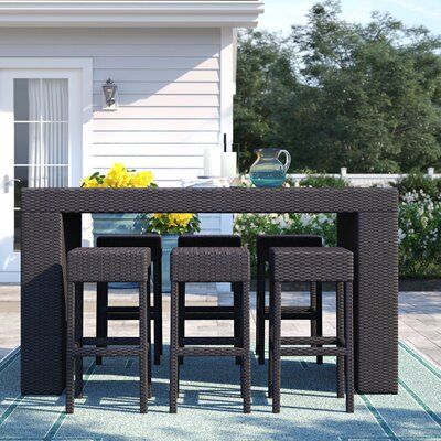 Sol 72 Outdoor™ Create a relaxing getaway for your next backyard get-together with this 7-piece bar height dining set. It's crafted with sleek, modern lines from resin wicker-wrapped aluminum frames for year-round weather resistance. The high top table features a glass tabletop on a simple wicker base. Six backless bar stools give friends and family plenty of seating room to gather round the pub table. The table has a space-saving open bottom where you can tuck the stools when you're not using t Outdoor Bar Sets, Bar Patio, Glass Table Top, Nursery Furniture Sets, Bedroom Furniture For Sale, Patio Bar, Glass Top Table, Bar Height, Patio Dining Set