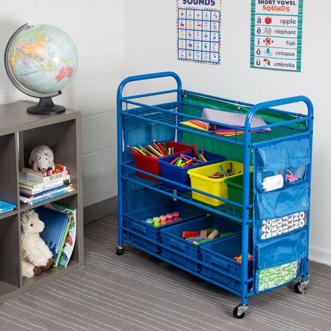 "The perfect accessory for any classroom, this all-purpose teaching cart provides plenty of pockets and bins to store all of the teaching essentials. Steel frame is durable and casters lock in place for stability. The perfect accessory for any classroom, this all-purpose teaching cart provides plenty of pockets and bins to store all of the teaching essentials. Side pockets on either edge allow for easy storage of writing utensils, flash cards and other small items while the bins in the center ho Organizing School, Craft Storage Cart, Cubby Bins, Organization Cart, Arts And Crafts Storage, Teacher Activities, Classroom Storage, Pocket Storage, Rolling Storage