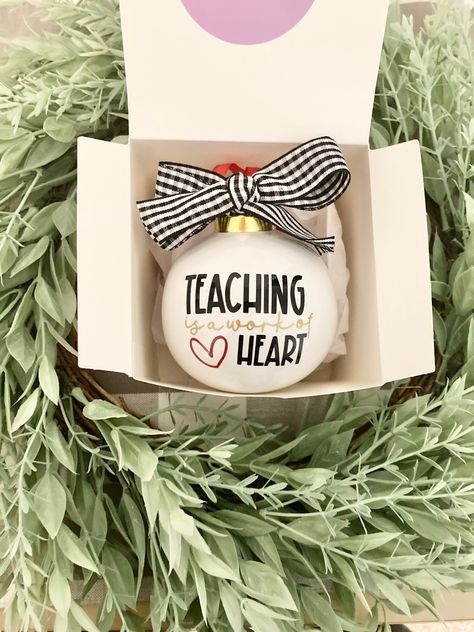 "Teacher Gift Christmas ornament, Teaching is a Work of Heart, Personalized Teacher Gift, Unique Teacher Gift, Gift for Teacher, Teachers \"Teaching is a Work of Heart\" ceramic ornament. The perfect personalized gift for every teacher pouring their hearts into your little one!  - Measures 3 inches  - Heavyweight ceramic ornament  - Back can be personalized with teacher's name  - includes individual gift box for every ornament purchased" Daycare Teacher Ornaments, Teacher Gift Cricut Ideas, Christmas Gift Idea For Teachers, Teacher Ornaments Cricut, Circuit Teacher Gifts, Teacher Ornament Gift, Teacher Acrylic Ornament, Christmas Gift For Preschool Teacher, Teacher Christmas Gift Ideas Cricut