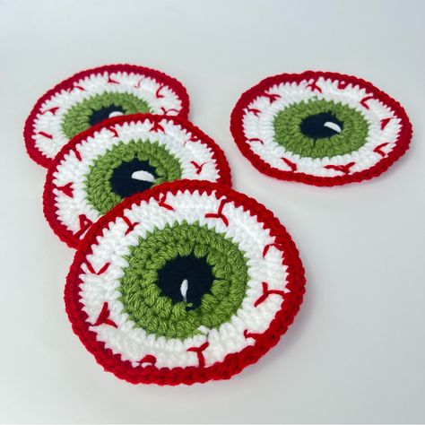 Spooky Set Of 4 Handcrafted Crochet Halloween Eyeball Coasters Handmade By Me Get Ready To Spook Up Your Halloween Decor With This Handcrafted Crochet Eyeball Coaster! Perfect For Adding A Creepy Yet Fun Touch To Your Party Or Coffee Table. Made With Love And Attention To Detail, This One-Of-A-Kind Coaster Is Sure To Be A Conversation Starter At Your Halloween Gatherings. Grab It Now To Add A Ghoulishly Delightful Twist To Your Home! 100% Acrylic Yarn Measurements Approximately 4 1/2” Halloween Crochet Halloween Door Decor, Spooky Crochet Coasters, Handmade Halloween Gifts, Crochet Halloween Placemats, Halloween Crochet Coasters Free Pattern, Halloween Crochet Garland, Small Halloween Crochet Projects, Halloween Decorations Crochet, Beetlejuice Crochet Pattern Free