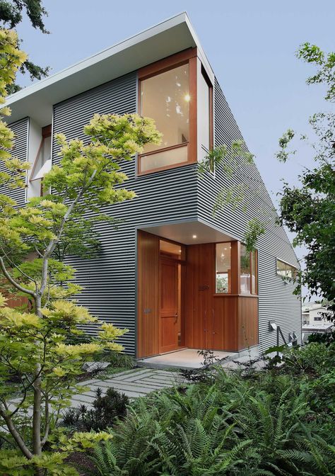 A modern house with corrugated metal siding and a wood front door and window frames. Home Siding Ideas Exterior, Shed Architecture, Corrugated Metal Siding, Modern Contemporary Homes, Metal Cladding, Seattle Homes, House Shed, Wood Architecture, Metal Siding