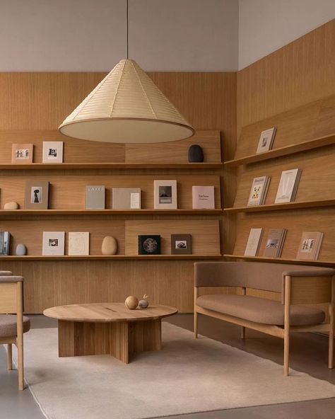 In Copenhagen's historic Ny Østergade, @new_mags has unveiled its flagship store, a quiet oasis designed by @normarchitects , showcasing a curated selection of lifestyle books, collectibles, and magazines. Inspired by the classic library, the design showcases these books as pieces of art, surrounded by carefully selected sculptures and objects. The use of natural materials like oak wood and golden sandstone creates a calm and gentle backdrop, encouraging visitors to delve into the diverse se... Long Study Table, Traditional Library, Lifestyle Books, Library Interior, Space Icons, Dragon House, Norm Architects, Store Interior, Office Interior