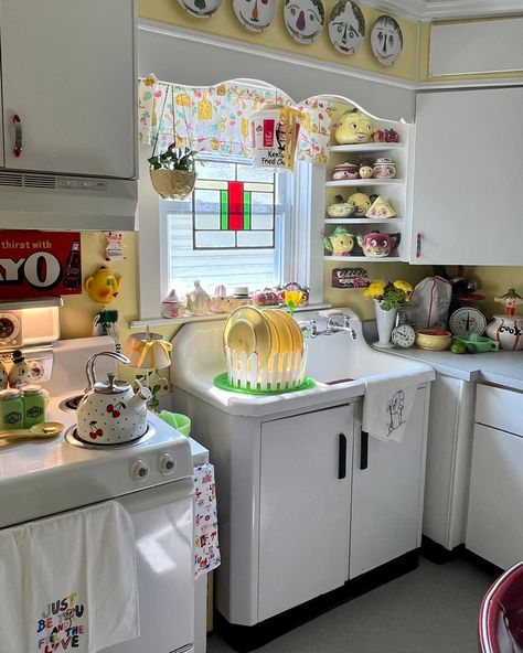 A yellow kitchen with white cabinets and appliances Granny Chic Decor Vintage Homes Cottage Style, Kitsch Kitchen Decor, Vintage Cabinets Kitchen, Retro Appliances Kitchen, Retro Kitchen Ideas 1950s, 70s Kitchen Aesthetic, Vintage Eclectic Kitchen, Granny Kitchen, Grandmacore Kitchen