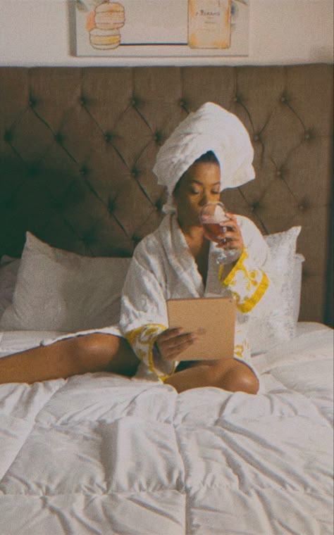 Black woman sitting on comfy bed wearing a thick white robe sipping wine while reading on a tablet her hair is wrapped in a terry white towel on top of her head. Black Woman Luxury, Luxury Self Care, Black Femininity Aesthetic, Embracing Femininity, Femininity Aesthetic, Luxury Lifestyle Aesthetic, Vision Board Printables, Aesthetic Woman, Vision Board Party