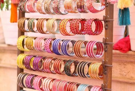 “Sparkle and shine at the wedding Celebration Showcasing an exquisite array of traditional and contemporary bangles to adorn your wrists. From delicate glass bangles in vibrant hues to intricate metal and Kundan designs, our stall has something for every style and preference. Let our bangle stall help you add a touch of glamour and tradition to your wedding look! #IndianWedding - #DesiWedding - #WeddingSeason - #BigFatIndianWedding - #IndianWeddingInspiration - #WeddingGoals - #IndianBride ... Bangle Station Mehendi, Contemporary Bangles, Bangle Bar, Mehndi Decor, Indian Wedding Inspiration, Glass Bangles, Bar Displays, Big Fat Indian Wedding, Wedding Look