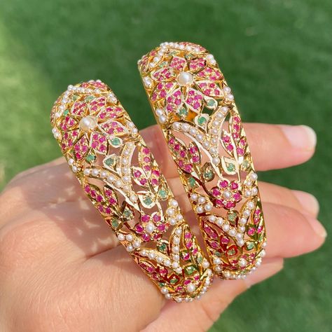 Featuring a pair of handcrafted multicoloured jadau kadas in 22ct gold. It has been embellished with precious rubies, freshwater pearls and emeralds. The bangles weigh 56.45 GMs Note: This product may or may not be ready at our shop in India. We shall require 0-2 weeks to process this item and export it to our USA warehouse (7-10 days time) from where it shall be shipped to you! You will NOT be paying any US Customs import duty later as it shall be paid by our American warehouse - and we shall b Indian Gold Bangles, 22k Gold Jewelry Necklaces, 22k Gold Bangles, Gold Bangles Indian, Gold Bangles For Women, The Bangles, 22k Gold Jewelry, Pearl Necklace Set, Gold Jewelry Necklace