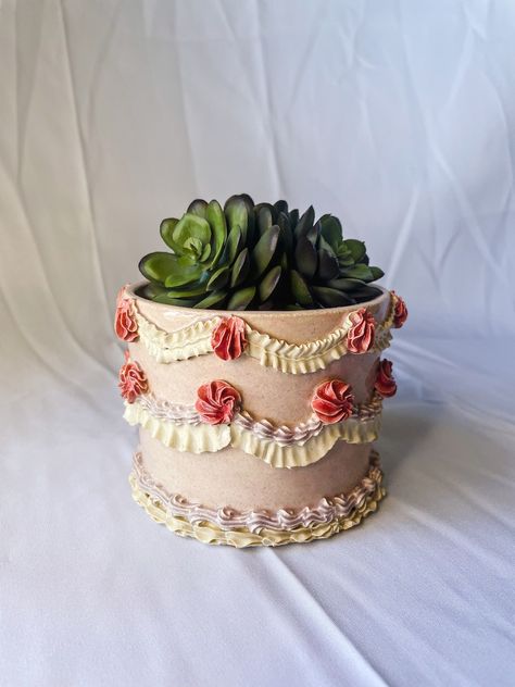 Ceramic Planter is sculpted to look like a cake featuring a light pink base with light purple, dark pink and white vintage cake piping. The piece features a whole in the bottom for water draining. Vintage Cake Piping, White Vintage Cake, Indoor Plants Succulents, Clay Candy, Pot Cakes, Purple Ceramic, Cake Piping, Bakery Kitchen, Bakery Decor