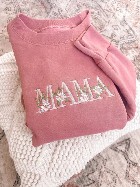 Crafted with love, this 100% Cotton Pink Sweatshirt adds comfort and warmth to any mom's wardrobe. The word 'Mama' is elegantly embroidered across the front, enhanced by a string of dainty daisies that wrap around each letter. This sweatshirt is not only comfortable but also a fashion statement. Its cozy crewneck makes it perfect for those chilly days or relaxed evenings at home. The Floral Mama Sweatshirt is an ideal gift for any occasion Valentines or Mother's Day. Mom Personalized Gifts, Things To Get Mom For Christmas, Embroidery Machine Projects, Embroidering Ideas, Motherhood University, Mama Embroidered Sweatshirt, Mama Embroidery, Mom Christmas Gifts, Embroidery Machine Designs