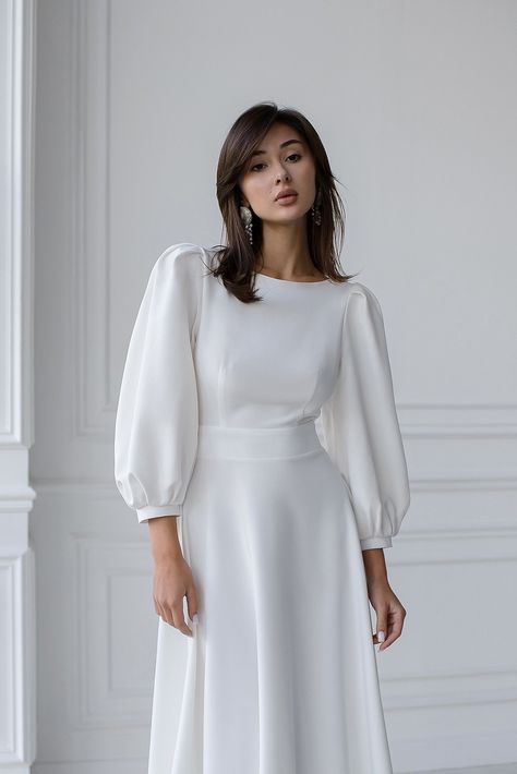 Captivate the room with the ELAGIA White Backless Puff Sleeve Midi Dress. The perfect fusion of sophistication and allure, featuring puff sleeves and a stunning backless design. #whitedress #backlessdress #puffsleeve #midi #ElagiaFashion #sophisticatedstyle #femininecharm #dressfashion #glamorouslook #etherealbeauty High Neck Puff Sleeve Dress, Puff Full Sleeve Dress, White Dress Puffy Sleeves, Full Sleeves Dress, Grad Outfits, Eid Dress, Puff Sleeves Dress, Nikah Dress, Trendy Suits