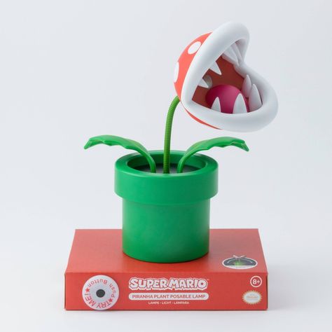 Brighten up your room, gaming den or living space with this collectible Super Mario Mini Piranha Plant Posable Lamp. Complete with a fully posable green stalk, you can position the flexible Venus fly trap style Piranha Plant head to shine bright white LED light from its mouth to wherever it is most needed. Gamers of all ages will want to own this fun and practical desktop light which stands at 6" tall and is anchored by a green plant pot shaped base. Powered by 3x AAA batteries (not included), y Nintendo Room, Green Plant Pot, Trap Style, Room Gaming, Gamer Decor, Piranha Plant, Winter Wedding Guests, Fly Trap, Venus Fly Trap