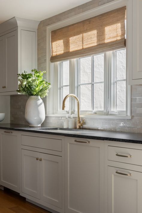 Kitchen with natural straw window shade Kitchen Sink Roman Shade, Kitchen Window With Backsplash, Kitchen Sink Picture Window, Roman Shades For Kitchen Windows, Roman Shades In Kitchen Window, Large Window Kitchen Sink, Triple Window Over Kitchen Sink, Picture Window Above Kitchen Sink, Kitchen Tile Around Window