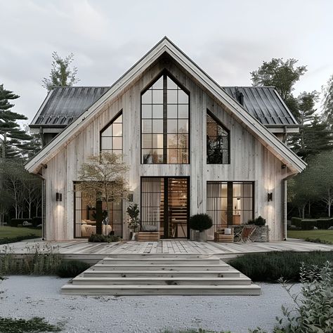 This image showcases a stunning split-level Scandinavian-style home featuring a classic gabled roof and modern design. The exterior is clad in weathered wood siding, complemented by large, floor-to-ceiling windows that flood the interior with natural light. A spacious wooden deck with steps leads to the entrance, surrounded by neatly maintained plants and minimalist outdoor furniture. This home combines rustic charm with contemporary elegance, nestled in a serene, forested landscape. Window Model Architecture, Twin Gable House Exterior, Stacked Split Level Home, Front Porch With Gable, Modern Scandinavian Architecture, Split Level Barndominium, Scandinavian Style Home Exterior, Nordic Cottage Exterior, Homestead House Design