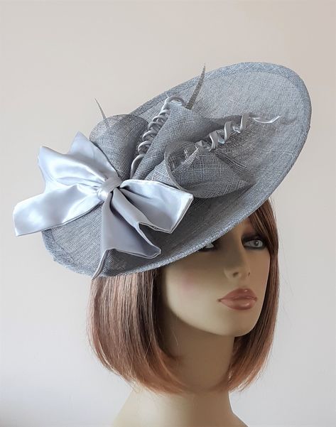 "MADE TO ORDER An elegant silver grey saucer fascinator ideal for weddings, Ascot, races or special occasion. The hat is hand blocked in sinamay and finished with elegant silver satin bow and handmade calla lilies.   Measuring approx 12\" across the headpiece is lightweight, comfortable to wear and fixed onto a headband.   This headpiece can be made in other colours or customised.  If you would like a custom order please check out my website: www.linclyburn.com and get in touch.  Unfortunately, I no longer accept returns but will happily send fabric swatches for colour matching to avoid disappointment." Silver Fascinator, Special Occasion Hats, Ascot Races, Wedding Mother Of The Bride, Fascinator Wedding, Sinamay Fascinator, September Wedding, Wedding Hats, Fascinator Hats