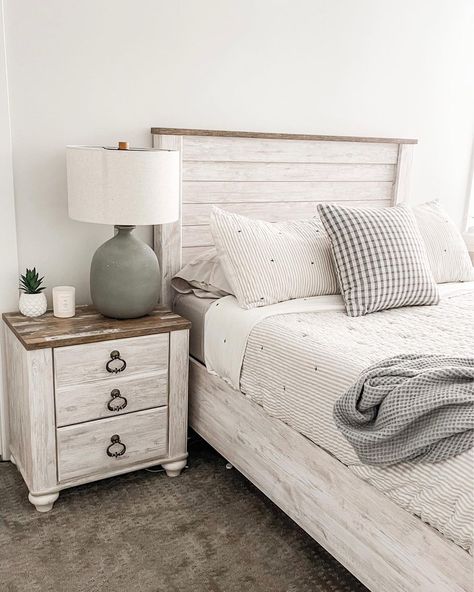 Two-toned rustic wood and white nightstand is perched next to a whitewashed wood shiplap bed in this bedroom. The bed is clad in white and gray striped bedding. Whitewash Bedroom Furniture Decorating Ideas, Guest Bedroom Ideas White Bed Frame, Whitewash Bed Frame, Whitewashed Wood Nightstand, White Headboard Bedroom Ideas Wood, White Washed Bed Frame, Whitewashed Bedroom Furniture, White Washed Headboard, Rustic White Bedroom Furniture