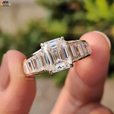 2.56 CT Emerald Cut Colorless Moissanite Ring, Vintage Engagement Ring, 1.94 TCW Side Stone Baguette Cut, Channel Set Ring, Ring For Women, Emerald Cut Moissanite Engagement Ring, Moissanite Wedding Ring, Gift For Her, Baguette Ring, Antiquediamondjewels The stones in the ring are cut and polished by our craftsmen and the ring is then handmade by our artist. All diamonds or stones used by us are conflict-free. They are pure moissanite and are not treated to enhance color or clarity. Center Stone Emerald Cut Moissanite Engagement Ring, Channel Set Rings, Vintage Inspired Engagement Rings, Vintage Style Engagement Rings, Emerald Cut Moissanite, Engagement Ring For Women, Baguette Ring, Diamond Jewel, Ring Moissanite