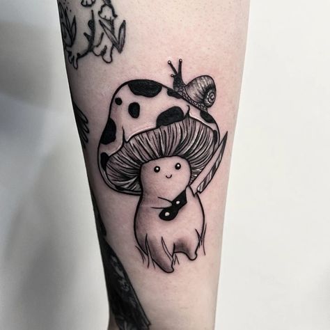 Black and grey tattoo of a mushroom man holding a little knife with both of his hands. There is a small snail on the top of the mushroom man's head on one side Evil Mushroom Tattoo, Goofy Mushroom Tattoo, Mushroom Tattoo Ideas For Men, Mushroom Knife Tattoo, Cute Animals Holding Knife Tattoo, Mushroom With Knife Tattoo, Lady With Mushroom Head Tattoo, Mushroom Holding A Knife Drawing, Mushroom Animal Tattoo