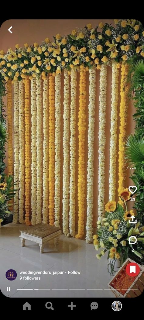 Flower Haldi Decor, Flower Backdrop For Ganpati, Backdrop Decorations Traditional, Flower Decoration For Function, Flower Decoration For Engagement At Home, Grah Shanti Decor At Home, Indian House Decor Wedding, Curtain And Flower Backdrop, Tamil Wedding Backdrop