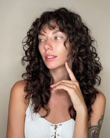 Top 18 Beautiful Hairstyles For Curly Hair to Inspire You Short Length Haircut For Curly Hair, 2b Haircut Bangs, Layered Curly Hair Medium Length, Haircuts For Round Faces Long Layered Curly Hair, Medium Length Curly Shag Hairstyles, Naturally Curly Shag Haircut Long, Shaggy Bangs Curly Hair, Curly Hair Haircut Women, Grease Hairstyles For Long Hair