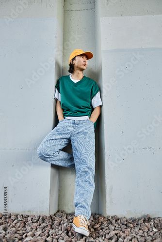 Stock Image: Vertical portrait of young Asian man wearing colorful street style clothes standing by concrete wall in urban setting Queer Street Style, Japan Street Style Men, Men Standing Poses, Mens Outfits Plus Size, Taiwan Street Fashion, Mens Skater Style, Dr Lemon, Photoshoot Fits, Hip Hop Style Men