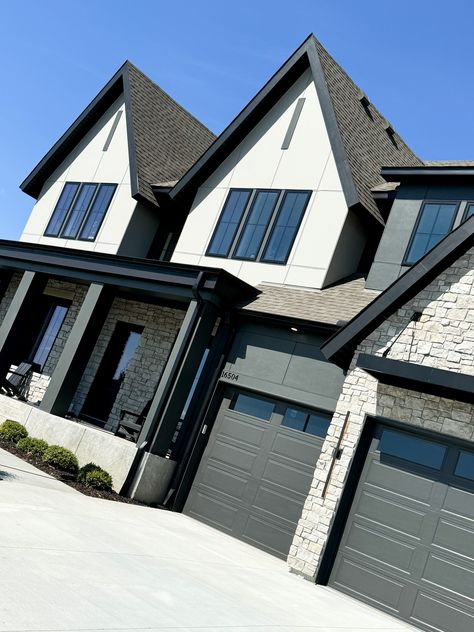 We continue to see black and white exteriors in many of the new construction homes featured in the 2024 Fall Parade of Homes! This particular example is stunning how it also pairs a more organic style stone to the front entryway and garage, giving it amazing curb appeal!!   New Construction | Home Trends 2024 | Home Design | Minnesota Home Trends White And Black Craftsman Exterior, Black And White Exterior House, Black White Exterior, White House Black Trim, White Exterior Houses, Exterior Inspiration, Minnesota Home, Craftsman Exterior, Front Entryway