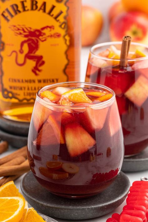 Fireball Sangria garnished with fruit slices. Carmel Apple Sangria Recipes With Fireball, Sangria Punch Bowl, Caramel Apple Sangria With Fireball, Fireball Apple Cider Sangria, Fireball Caramel Apple Sangria, Fireball Sangria Recipe, Drinks With Fireball Whiskey, Fireball Balls, Fall Adult Drinks