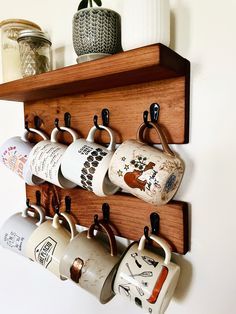 Get ready to transform your kitchen into a chic, organized, and highly functional space! These must-have accessories are perfect for making your cooking experience smoother and more enjoyable. You deserve a kitchen you love! 💖 #OrganizedLiving #StylishKitchen #CulinaryGoals #DesignAndFunction Wooden Coffee Mug Holder, Coffee Mug Storage Display, Hang Coffee Mugs On Wall, Mugs On Hooks, Wall Shelf Coffee Bar, Coffee Station Mug Display, Coffee Bar Hanging Mugs, Kitchen Mugs Organization, Bookshelf Turned Coffee Bar