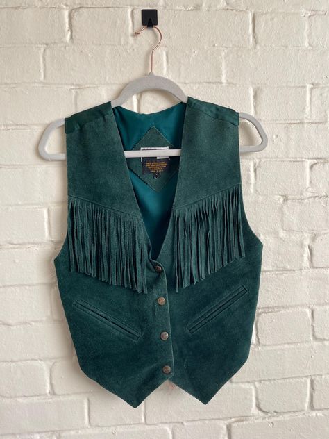 Mona Mode Vintage Mona Mode Western Biker Leather Suede Vest Leather suede waistcoat made in India So hippie, Boho vintage vest in green Fabric is suede leather with 4 snap front closure and with fringed chest.  Back is silky material with tie. Size Small  Measurements  18" armpit to armpit across the front  21" long from shoulder to hem 23" from shoulder to longest point  good preloved vintage condition Western Fringe Vest, Suede Fringe Vest Outfit, Western Vest Outfit, Dnd Cowboy, Suede Vest Outfit, Fringed Vest Outfit, 70s Western Fashion, Suede Waistcoat, Thrift Inspiration