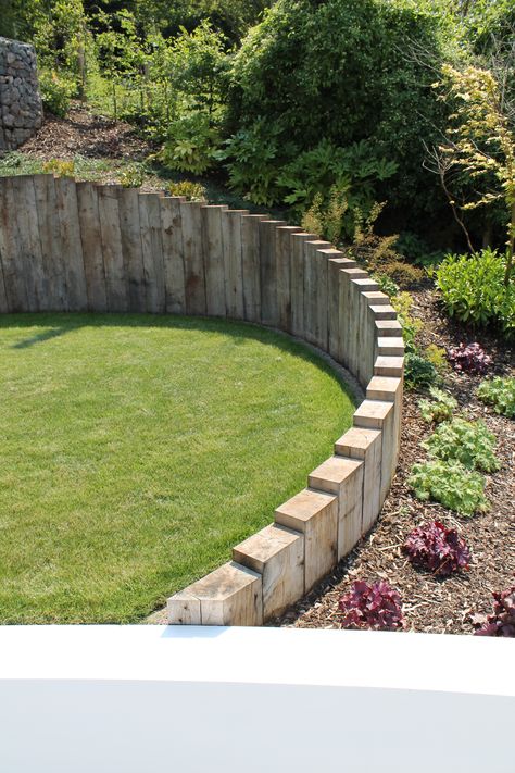 Oak sleepers are used through out the project, set vertically to follow organic curves, retain ground and blend different levels within the garden. Railway Sleepers Retaining Wall, Curved Retaining Wall Garden, Levels Garden Ideas, Railway Sleepers Garden Retaining Walls, Curved Sleeper Wall, Railway Sleepers Garden Curved, Corner Sleeper Planter, Garden Design With Sleepers, Curved Garden Wall Ideas