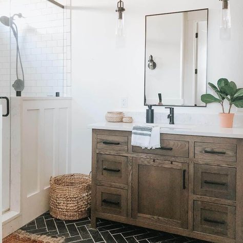 A green plant sits on the white bathroom counter of a rustic wood vanity. A glass door reveals a white subway tile walk-in shower wall, and a brown mat is laid on the black herringbone tile floor...   Image: hestershomestead Double Vanity Ideas, Lauren Diy, Home Depot Vanity, Ideas For Small Bathrooms, Black Faucet, Black Wall Mirror, Vanity Ideas, Bathroom Sconces, Small Bathrooms