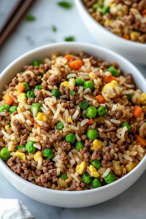 Close-up of ground beef fried rice with peas, carrots, and corn. The dish is garnished with fresh herbs, and the rice appears fluffy with a golden hue from the seasoning. Ground Beef And Peas Recipes, Ground Beef Fried Rice, Ranch Potatoes Baked, Peas And Carrots Recipe, Rice With Peas, Peas And Corn, Beef Fried Rice, Chicken Stuffing Casserole, Bacon Ranch Potatoes