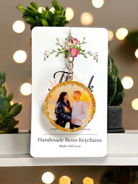 A beautiful couple photo resin keychain is a heartfelt keepsake that encapsulates the essence of love in a tangible form. The delicate resin encases a cherished photograph, capturing a moment frozen in time, radiating with the warmth and tenderness shared between two souls✨❤️ #Resinkeychain #Couplephotoresinkeychain #Giftideas #giftideasforher #amarcrafts Resin Art Photo Keychain, Resin Keychain Photo, Resin Photo Keychain Ideas, Resin Couple Gift Ideas, Resin Photo Keychain, Photo Resin, Resin Idea, Couple Keychains, Diy Resin Phone Case