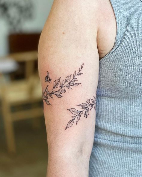 Greenery Wrap Tattoo, Vine Tattoo Bicep, Cherry Blossom Arm Wrap Tattoo, Tattoo Ideas Female Bicep, Wrap Around Tattoo Design, Fine Line Botanical Tattoo, Bee Flower Tattoo, Botanical Wrap Tattoo, Bee And Flower Tattoo