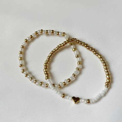 Set Of Two Handmade Gold And White Beaded Bracelets With A Gold Heat In The Middle. Perfect Gift For A Mother, Friend, Sister, Aunt Or Yourself! Small Bead Bracelets Ideas, Bracelet Buisness, White Beaded Bracelets, Bracelet Business, Small Bead Bracelet, Clay Bracelets, Multicolor Bracelet, Wrist Stacks, Bracelet Inspo