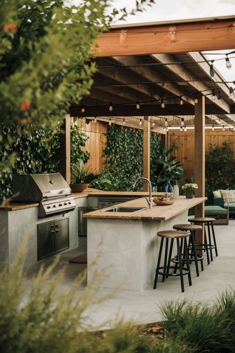 Outdoor kitchen under a wooden pergola with grill, sink, bar stools, and potted plants. Outdoor Bbq Terrace, Outdoor Kitchen Container, Outdoor Summer Kitchens, Outdoor Bbq Seating Area, Kitchen To Patio Transition, Outside Bbq Ideas, Small Outdoor Kitchen And Bar, Outdoor Kitchen And Bar Design, Outdoor Kitchen On Side Of House