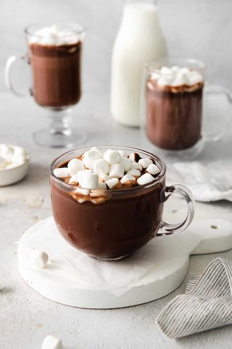 A glass mug of hot chocolate with marshmallows on top, and more mugs of hot chocolate in the background Gluten Free Hot Chocolate, Dairy Free Egg Nog, Meaningful Eats, Mug Of Hot Chocolate, Hot Chocolate Toppings, Starbucks Hot Chocolate, Hot Chocolate With Marshmallows, Chocolate With Marshmallows, Classic Hot Chocolate