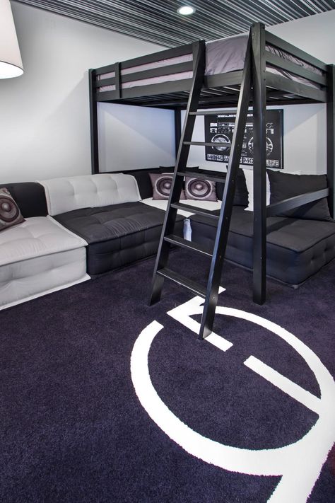 Black carpet with a white logo sets the stage for a stylish black and white bedroom and lounge area. A loft bed sits over a sectional with alternating black and white cushions. Speaker throw pillows and a boom box picture add a music themed decor to the room. A striped ceiling brings a tight pattern to the design. Contemporary Kids Bedroom, Young Mans Bedroom, Music Themed Rooms, Modern Loft Bed, Cool Bedrooms For Boys, Teenager Bedroom Boy, Loft Bed Plans, Diy Loft Bed, White Sectional