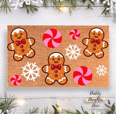 Welcome the holiday spirit with our charming Gingerbread Wonderland Doormat! Featuring delightful gingerbreads, festive peppermint swirls, and delicate snowflakes, this doormat is the perfect addition to your Christmas porch decor.  𝐏𝐫𝐨𝐝𝐮𝐜𝐭 𝐈𝐧𝐟𝐨𝐫𝐦𝐚𝐭𝐢𝐨𝐧 Our door mats are completely hand painted and sealed with a protectant spray. Each design is carefully placed, painted and preserved! Since each mat is hand painted colors and placement may slightly vary. Our welcome mats have a Christmas Rugs Outdoor Diy, Door Mat Christmas Diy, Door Mat Ideas Diy Rugs, Paint Your Own Doormat, Christmas Door Mat Ideas Diy, Hand Painted Door Mats, Door Mat Painting Diy, Christmas Doormat Ideas, Christmas Doormat Diy