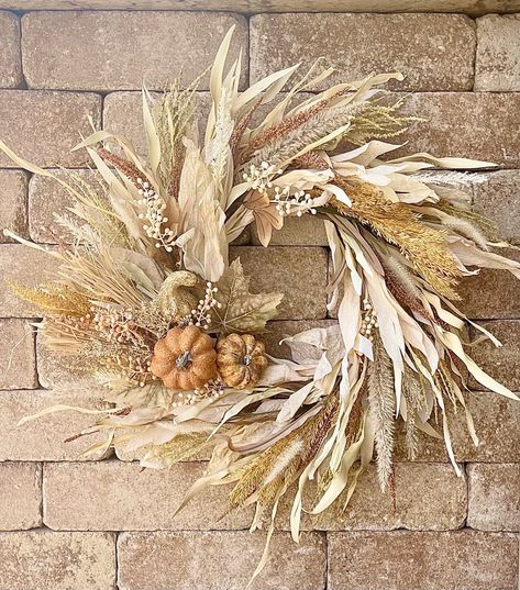 Welcome the subtle beauty of autumn with this Neutral Fall Corn Husk Wreath, perfect for adding an elegant touch to your front door. This stunning wreath features beige pumpkins, natural wheat, and delicate berries, harmoniously combined with cream pampas grass. The soft, neutral tones and farmhouse foliage create a timeless piece that enhances any home decor. Ideal for those who appreciate understated elegance, this autumn wreath brings the serene charm of the harvest season right to your doors Front Door Fall Garland, Corn Shuck Wreaths, Wheat Wreath Diy, Homemade Fall Wreaths, Cornstalk Wreath, Corn Husk Decor, Cream Pampas, Calligraphy Pumpkin, Door Beige