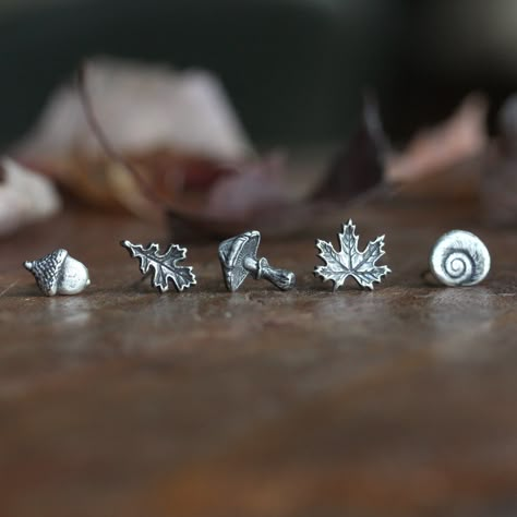 One single Autumn earring stud ~ sculpted in fine silver with sterling silver posts and backings. Dainty, elegant and perfect for every day. Choose from  Acorn, Oak Leaf, Mushroom, Maple Leaf or Shell. This listing is for ONE (1) single stud earring. These earrings feature tiny hand sculpted, autumnal themed nature treasures that were molded in fine silver (.999 / 99.9% pure silver) from an original design and then hand sculpted with further details before firing. The posts are sterling silver (.925) with sterling silver clutch backings. They are available in two different sizes that you can select at checkout: ✥ Small ~  The Acorn earring measures approximately 6mm wide x 8mm high;  The Oak Leaf earring measures approximately 5mm wide x 10mm high;  The Mushroom earring measures approximat Nature Stud Earrings, Fun Stud Earrings, Maple Leaf Jewelry, Mushroom Earring, Oak Leaf Earrings, Acorn Earrings, Autumn Earrings, Autumn Jewelry, Mushroom Earrings