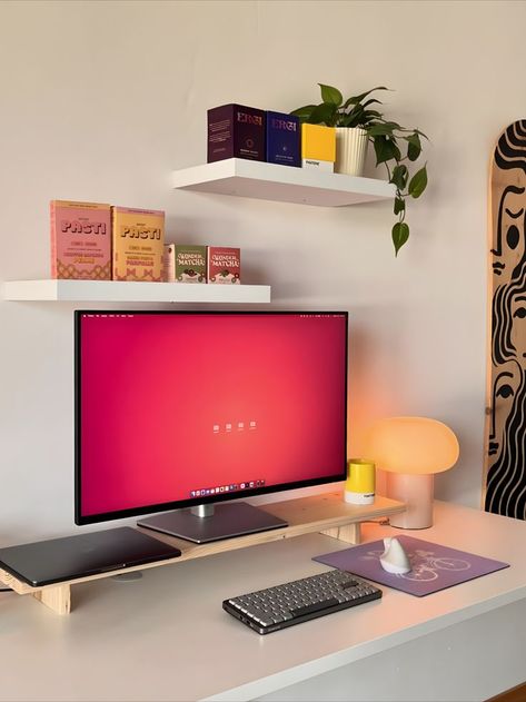 A minimalist and cozy home office setup featuring a large monitor on a sleek desk, surrounded by vibrantly colored decor items including books, a plant, and an artistic skateboard on the wall. The workspace is characterized by its clean design and pops of color that create a lively and inspiring environment. Minimal Desk Setup, Indian Room, Cozy Home Office, Desk Inspiration, Aesthetic Space, Office Room Decor, Simple Room, Dreamy Room, Teen Bedroom Decor