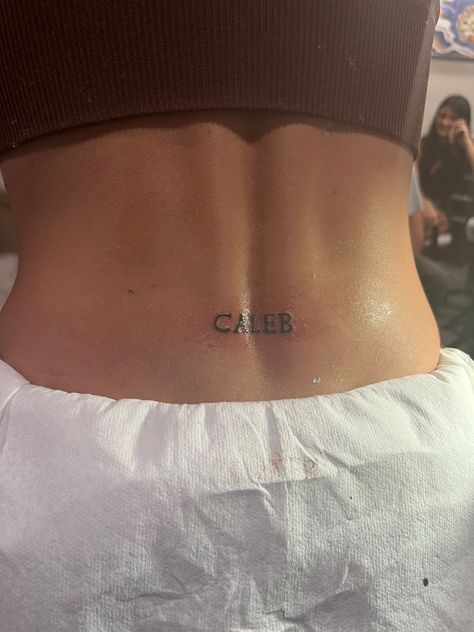 Girly Word Tattoos, Back Mini Tattoo, Cute Dainty Tramp Stamp, Letter Tramp Stamp, Spine Tattoo With Tramp Stamp, Trampstamp Tattoo Words, Lower Back Name Tattoos, Spine And Tramp Stamp Tattoo, Lucky You Tramp Stamp