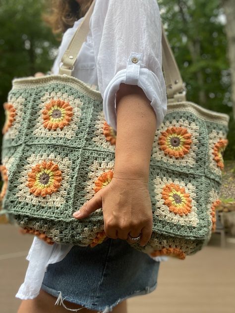 This sunflower crochet bag can be fabulous as shoppers tote or daily tote  Everybody likes crochet granny square. Perfect color transitions make this crochet bag quite flashy. Amazing style aside, this granny square bag also features handcrafted. If you like the hippie style ,this hippie bag will be perfect choice for you. The Granny Square bag will be send thoughtfully wrapped and secure. I used cotton yarn while making the crochet bag. Due to this yarn, the granny square bag is quite soft, yet extremely durable. . The main color of the colorful bag is green  and it is fully lined inside. As a lining, I 100% cotton linen durable fabric. the size is approximately 20*16 inches 100% handmade Lined with two small pockets inside Machine washable The bag color may vary slightly due to different Sunflower Crochet Bag, Green Granny Square, Crochet Sunflower Bag, Crochet Tote Bag Pattern, Sunflower Tote Bag, Sunflower Bag, Sunflower Crochet, Fall Bags, Granny Square Bag