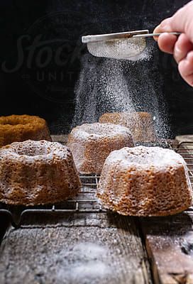 Dusting Cakes With Icing Sugar. | Stocksy United Cakes With Icing, Powder Cake, Food Photography Composition, Baking Photography, Dark Food Photography, Mini Bundt, Mini Bundt Cakes, Lava Cakes, Bundt Cakes