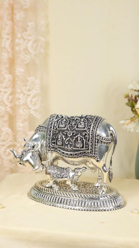 This silver idol Cow & Calf, made in pure silver 925 with Ashtalakshmi figurines on both sides, and such beautifully crafted piece is sure to bring positive vibes to your home Call | Watsapp: +91 95644 95644 Or visit us at : MG Rd, near Brindavan colony, Sriram Nagar, Vijayawada. #silver #silverarticles #silvergifts #silverpoojaarticles #silvergiftarticles #vijaywada #vja #silverdesigns #cowidol #calfidol #cow&calfidol #filgurines #ashtalakshmiidol # #cowsilveridol #gowmata #gowmatasilveridol Silver God Idols, God Idols, Silver Centerpiece, Silver Pooja Items, Gold Jewellry, Goddess Decor, Back Neck Designs, Antique Bridal Jewelry, Cow Calf