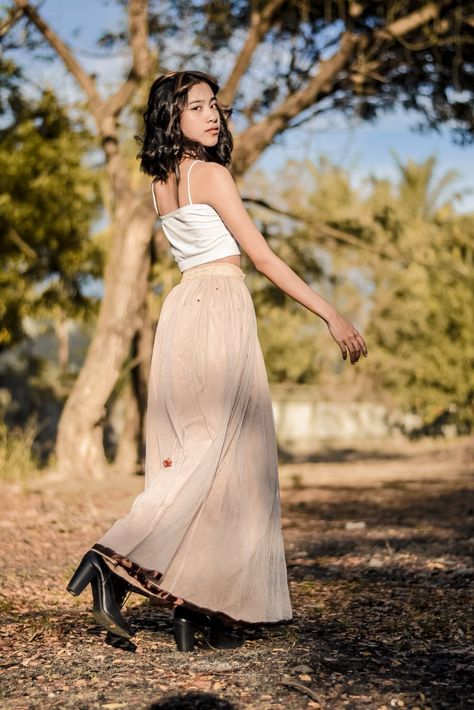 A Young Woman in a Long Skirt Looking over her Shoulder · Free Stock Photo How To Pose With Long Skirt, Long Skirt Pose Reference, Poses With Skirts Outfit Long, Poses For Skirt Outfits, Full Picture Poses, Pose With Long Skirt, Poses With Long Skirt, Poses In Long Skirt, Look Over Shoulder Pose