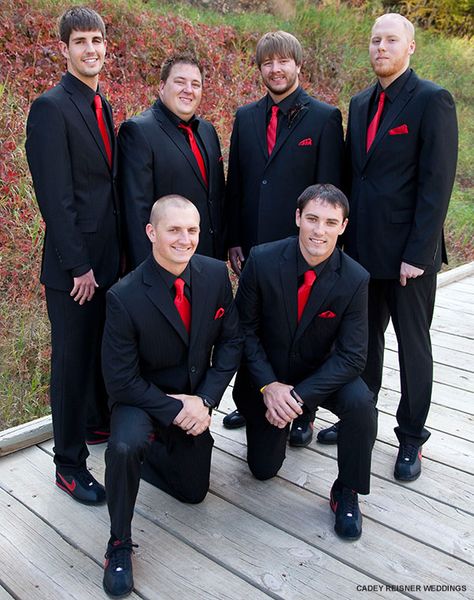 Classy matching tuxs with bright red ties - paired with comfy Nike sneakers Red Black Suit Men, Black And Red Tuxedo, Black And Red Tux, Black Suit Red Tie, Red Tux, Black Groomsmen Suits, All Black Tuxedo, Black Tuxedo Wedding, Suit For Groom