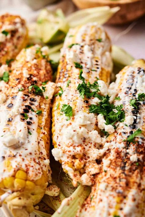 Grilled Mexican corn on the cob, reminiscent of Mexican Street Corn, topped with white sauce, crumbled cheese, chili powder, and cilantro. Best Mexican Street Corn Recipe, Street Corn On The Cob, Mexican Street Style, Corn In The Oven, Mexican Street Corn Recipe, Easy Side Dishes, Street Corn Recipe, Mexican Corn, Corn Recipe