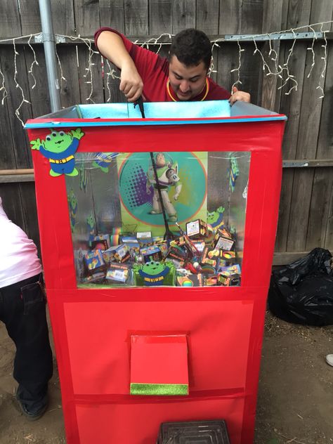 The Claw machine. DIY toy story Claw Machine Diy Arcade Games, Diy Toy Story Party Games, Disney Themed Carnival Games, Claw Toy Machine, Toy Story Carnival Games, Claw Machine Birthday Party, Disney Carnival Games, Toy Story Themed Party Games, The Claw Trunk Or Treat