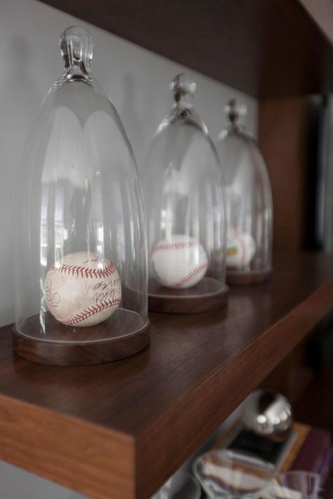 Designer Justine Sterling's client has loads of sports memorabilia and having these glass cloches made the perfect display for his signed baseballs. Sports Memorabilia Display, Baseball Man Cave, Glass Cloches, Memorabilia Display, Baseball Display, Interior Livingroom, Ultimate Man Cave, Baseball Room, Man Cave Basement